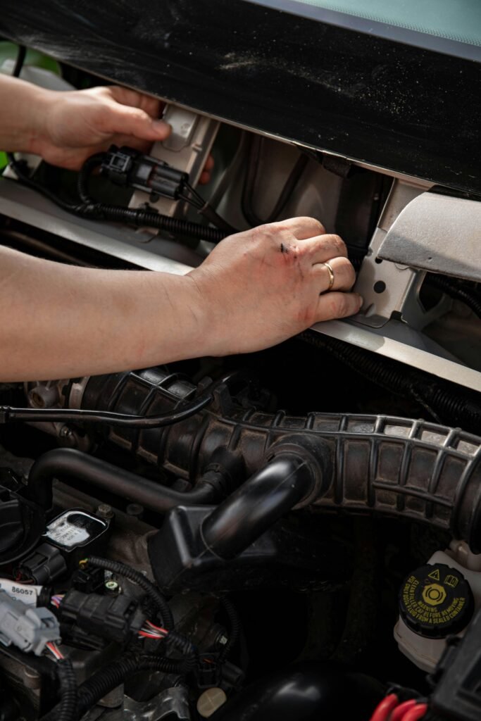 Close-up of a mechanic fixing car engine parts, showcasing hands-on expertise in repair.